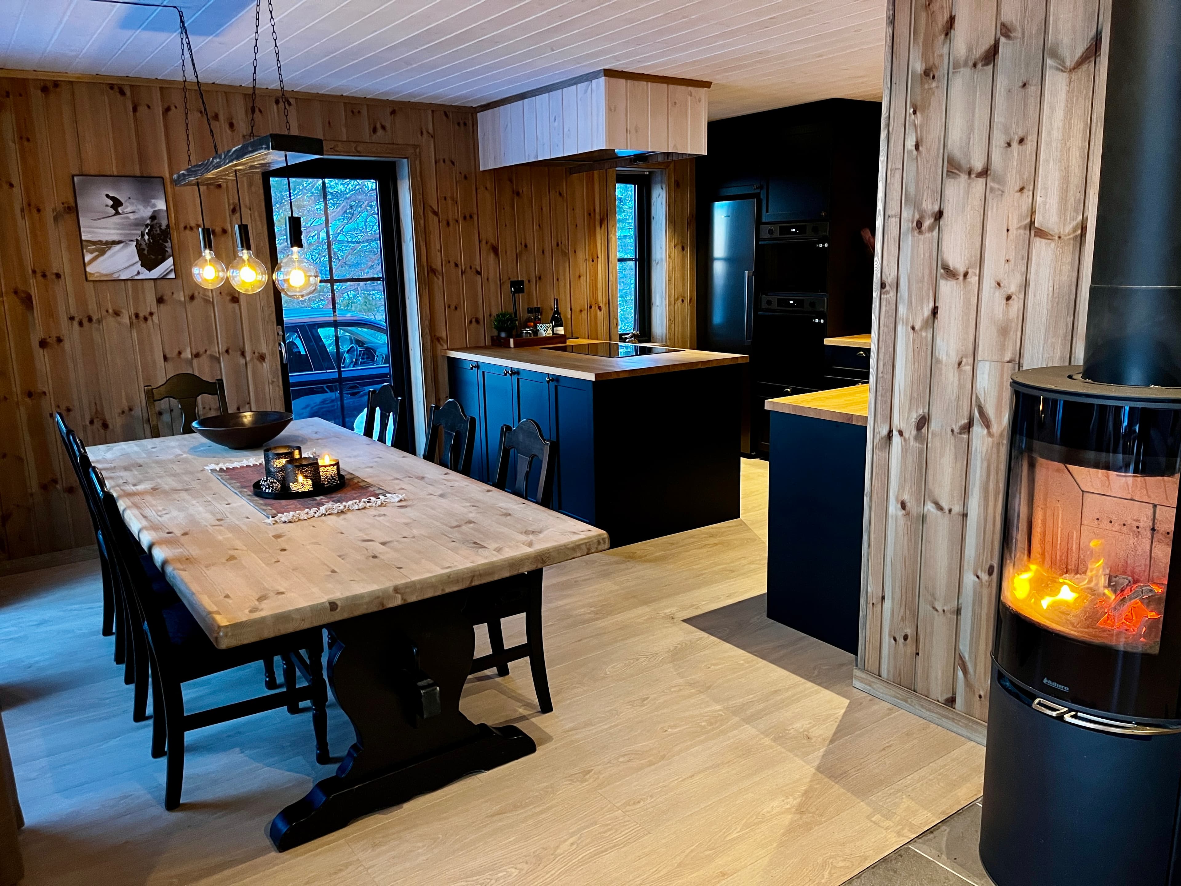 Gourmetkjøkken med kokeøy, spisebord og vedovn i Lindeview